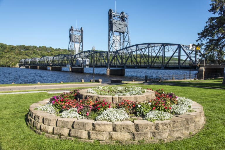 A flower bed in the foreground with the historic Stillwater liftbridge in the background on the St. Croix River.