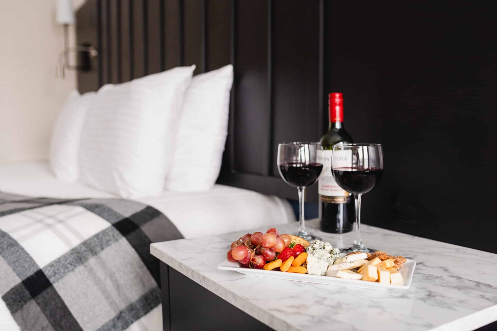 Bed and wine and cheese plate at our romantic getaway in MN