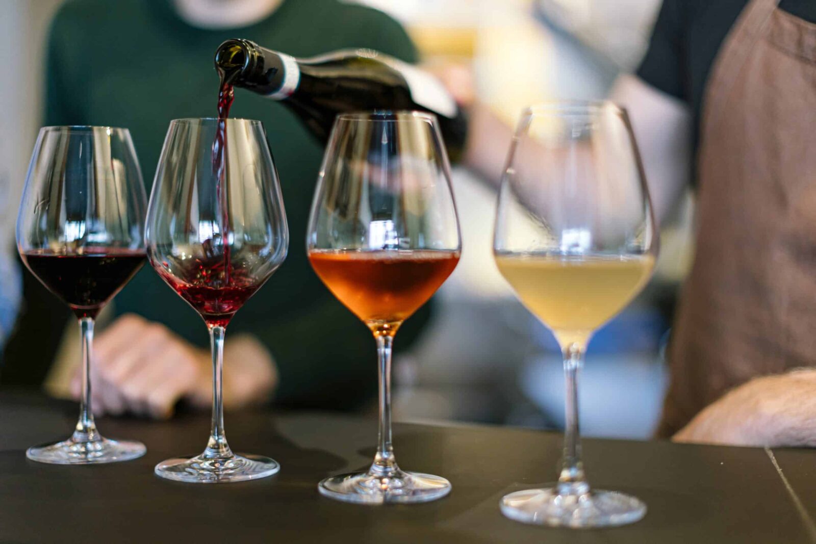 Sommelier pouring tasting flight of four wines at St. Croix Vineyards in Stillwater MN.